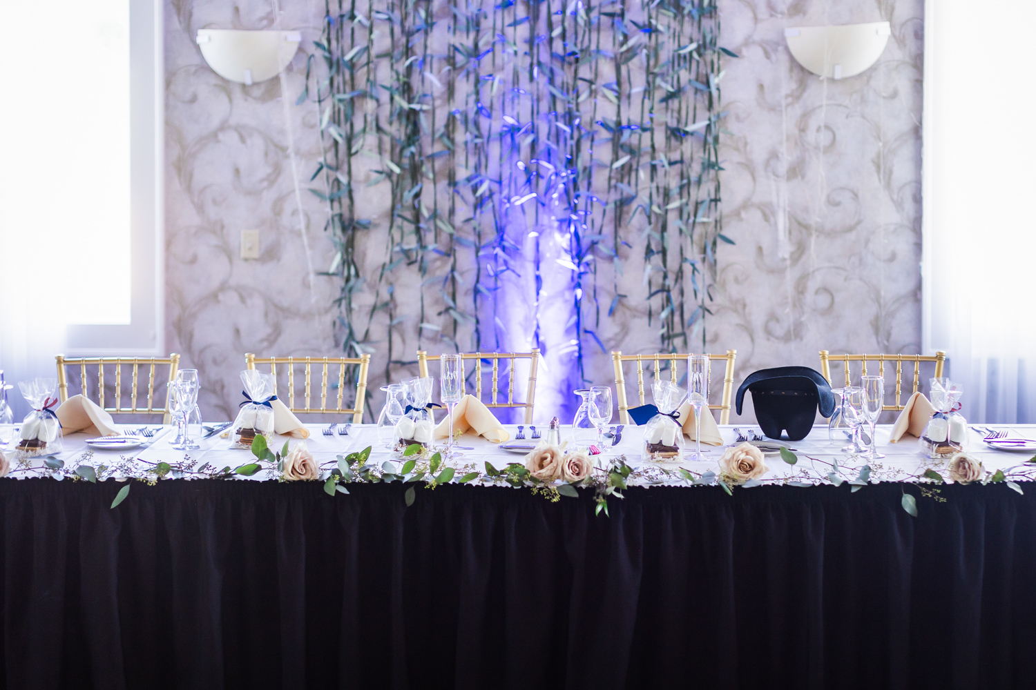 The newlywed's table with a black tablecloth and white flowers on top.